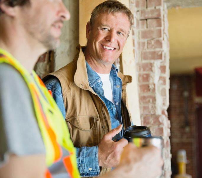 two construction guys chatting and drinking coffee