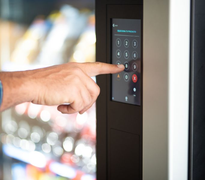 Close up of finger pushing buttons on a vending machine